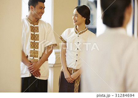 Two staff with hotel's uniform are chatting together Two staff with hotel's uniform are chatting together 31284694