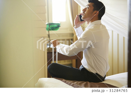 The businessman is looking and talking on phone in a room. 31284765