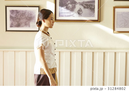 Beautiful staff is standing beside a wall with pictures. Beautiful staff is standing beside a wall with pictures. 31284802