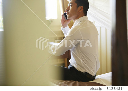 Young man is sitting and taking a phone call with happiness 31284814