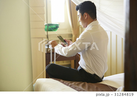The man was looking at the phone screen in a room 31284819