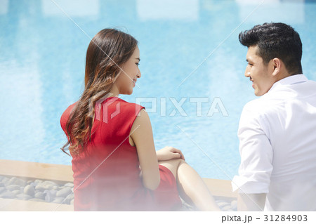 The couple is talking happily beside the pool 31284903