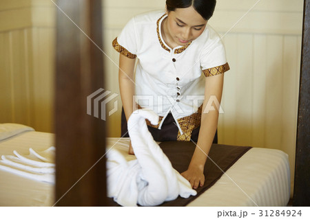 A photo of young staf preparing the bed in a room. 31284924