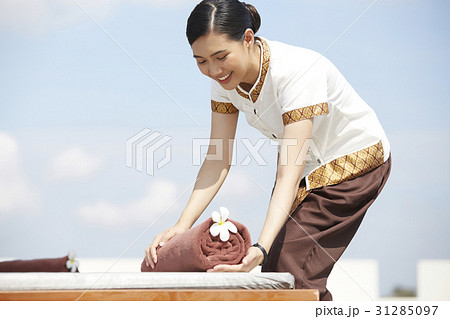 The housekeeper is putting towel on the chair for customer 31285097