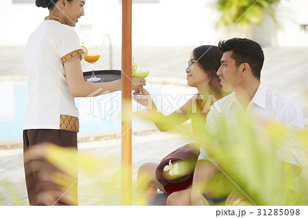 the waitress is inviting a couple to drink juice 31285098