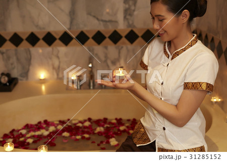housekeeper is lighting candle in the bathroom. housekeeper is lighting candle in the bathroom. 31285152