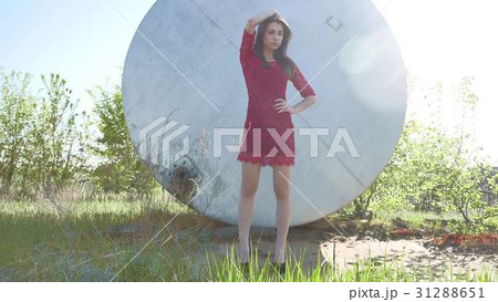 Strict girl. A serious girl stands near a barrel Strict girl. A serious girl stands near a barrel 31288651