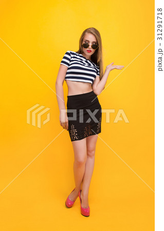 Casual style dressed young woman standing against 31291718