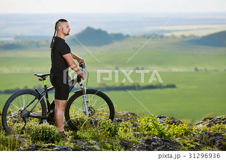 Cyclist standing with mountain bike on background Cyclist standing with mountain bike on background 31296936
