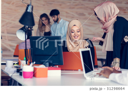 Two woman with hijab working on laptop in office. Two woman with hijab working on laptop in office. 31298664