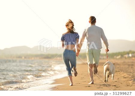 two young people running on the beach kissing and 31299627