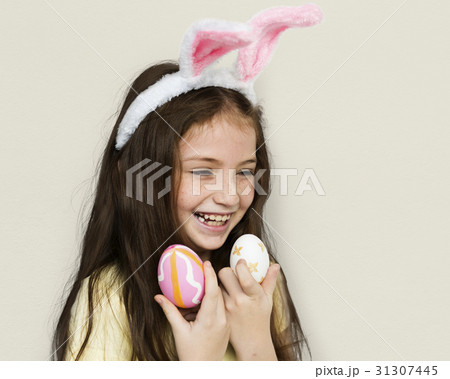 Kid with a bunny hairband holding eggs Kid with a bunny hairband holding eggs 31307445