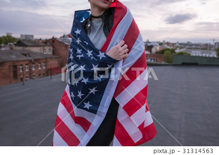 Girl dressed in USA flag on city background 31314563