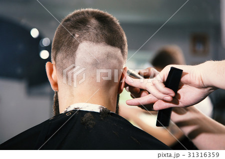 Professional barber doing a haircut 31316359