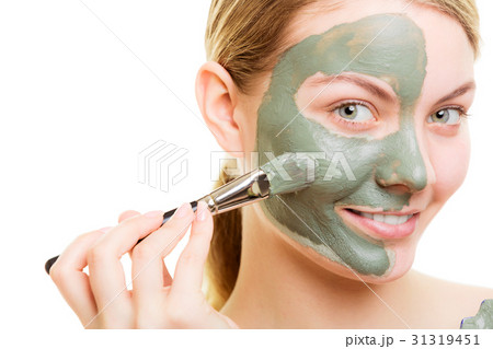 Woman applying with brush clay mud mask her face Woman applying with brush clay mud mask her face 31319451