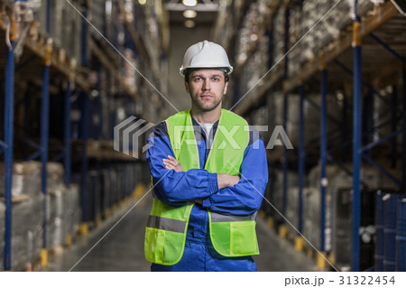 Warehouse worker standing between rows with boxes 31322454
