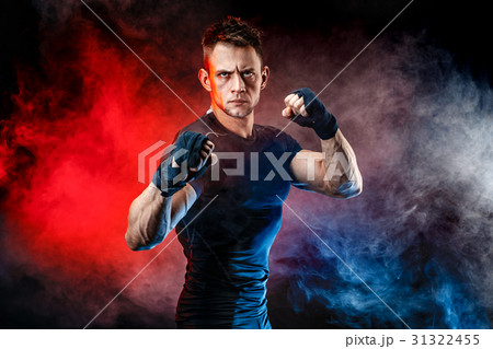 Studio portrait of fighting muscular man in smoke 31322455
