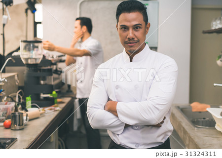 Smiling young asian chef in the kitchen interior. Smiling young asian chef in the kitchen interior. 31324311