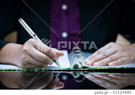 Businesswoman's hand signing document. 31324995
