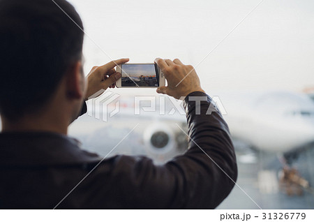 Man hand take picture of airplane using cellphone Man hand take picture of airplane using cellphone 31326779