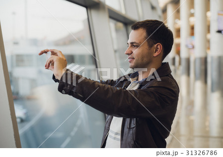 traveler with mobile phone at the airport taking traveler with mobile phone at the airport taking 31326786