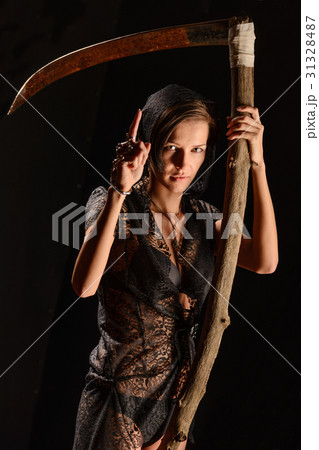 Girl in a black lace smock with scythe of death. Girl in a black lace smock with scythe of death. 31328487