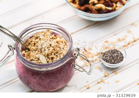 Smoothie topped with granola in a mason jar 31329639