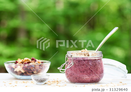 Smoothie topped with granola in a mason jar 31329640