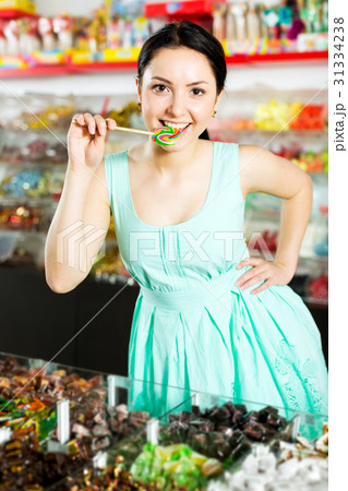 Woman posing to photographer with lollypop 31334238
