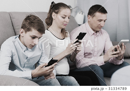 Parents and son using phones Parents and son using phones 31334789