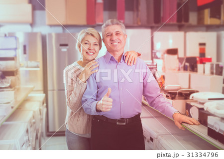 Adults are visiting shop of household appliances for buying goods Adults are visiting shop of household appliances for buying goods 31334796