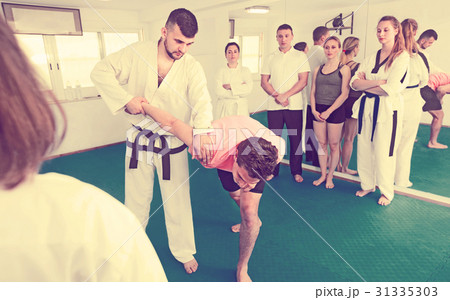 Coach showing new submission hold in taekwondo class 31335303