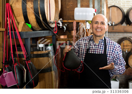 Seller holding spanish bota bag for wine Seller holding spanish bota bag for wine 31336306