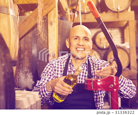 Mature male wine maker corking bottle of wine 31336322