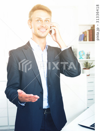 Male employee answering on phone at office 31336418