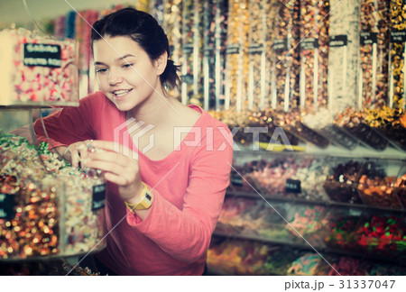 girl buying candies at shop girl buying candies at shop 31337047