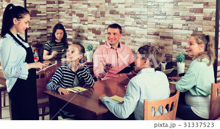 Adults with kids are giving order to cheerful waitress 31337523