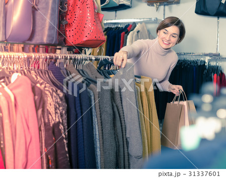 Glad woman choosing turtleneck sweater Glad woman choosing turtleneck sweater 31337601
