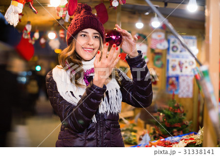 Beautiful girl choosing Christmas decoration Beautiful girl choosing Christmas decoration 31338141