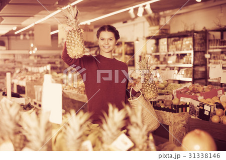 Girl buying ripe pineapple 31338146