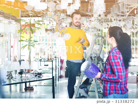 Man and girl choosing modern chandelier Man and girl choosing modern chandelier 31338272