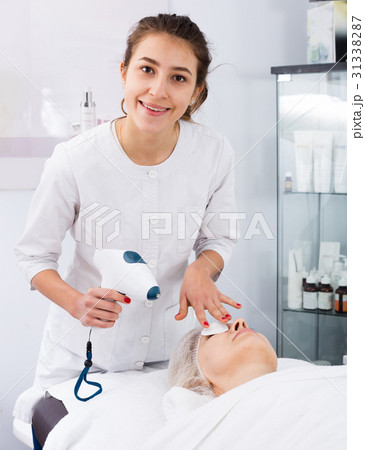 Aged woman making beauty procedures for face in spa salon Aged woman making beauty procedures for face in spa salon 31338287