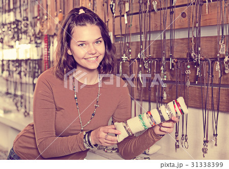 Girl seller offering fashionable bracelets and pendants Girl seller offering fashionable bracelets and pendants 31338399