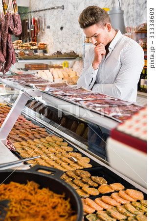 Young man choosing what kind of meat to buy 31338609