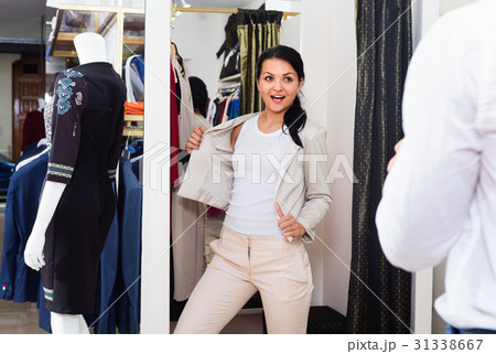 Couple choosing jacket and dress at boutique 31338667