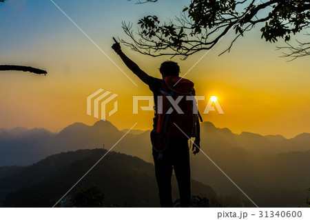 Hiking man stand relax on hill enjoying sunset Hiking man stand relax on hill enjoying sunset 31340600