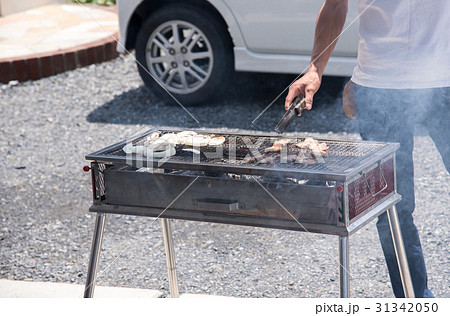 バーベキューで肉を焼く男性 バーベキューで肉を焼く男性 31342050