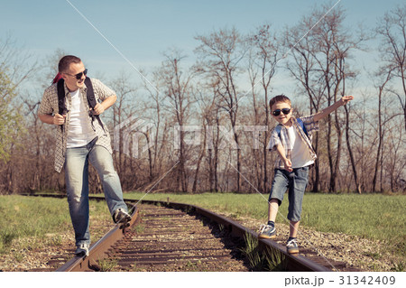 Father and son walking on the railway at the day time. 31342409