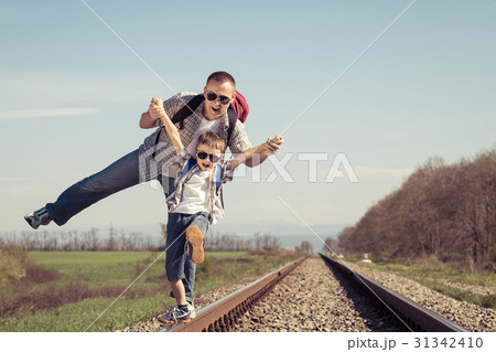 Father and son walking on the railway at the day time. Father and son walking on the railway at the day time. 31342410