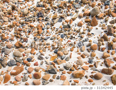 smooth round pebble stones on the sand backgound. 31342445